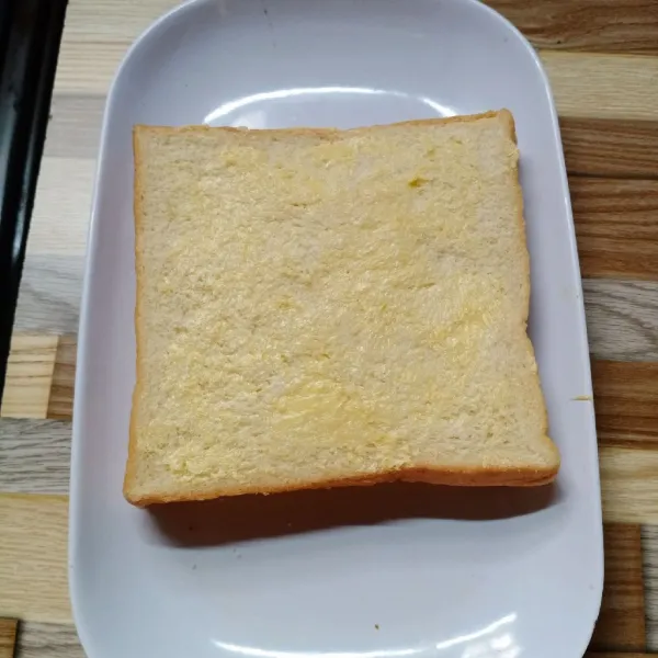 Tumpuk roti menjadi satu. Kemudian oles sisi atas dan bawah roti dengan margarin.