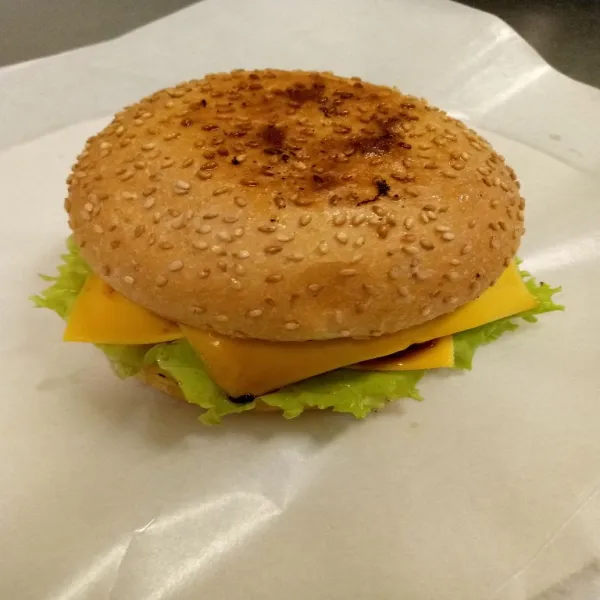2 pcs chesse di susun di atas patty dan berikan 3 pcs bawang bombay dan tuangkan 5 zig-zag murstad yellow