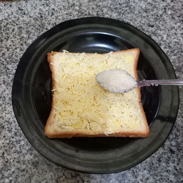 Beri gula pasir dan ratakan, tutup kembali bagian atas dengan roti tawar.