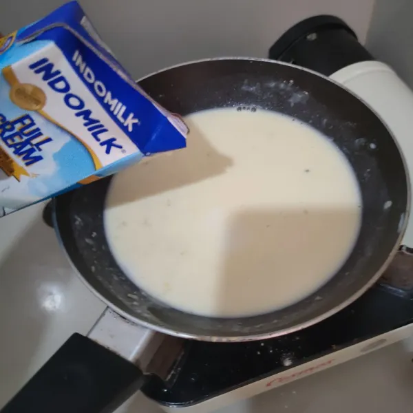 Beri susu sedikit demi sedikit sambil terus diaduk supaya tepung tidak menggumpal.