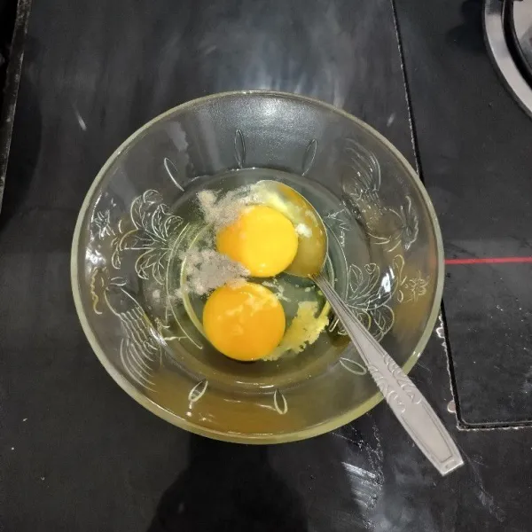 Pecahkan telur di dalam mangkuk. Tambahkan merica bubuk, kaldu jamur dan garam. Lalu kocok hingga rata.