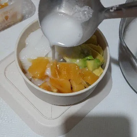 Tata buah dan es batu dalam mangkuk siram dengan saus santan.