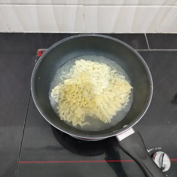 Rebus mie instan dalam air mendidih hingga matang. Angkat dan tiriskan.