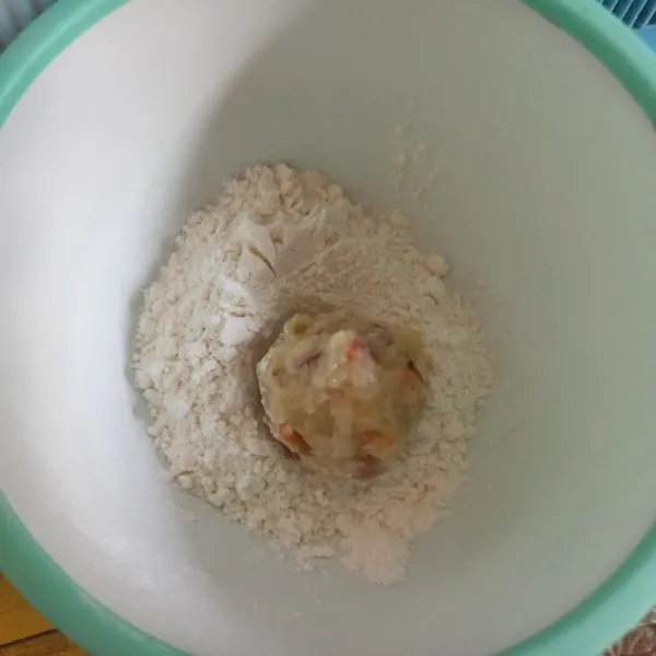 Ambil adonan secukupnya, bentuk bulat kemudian gulingkan ke dalam tepung kering.