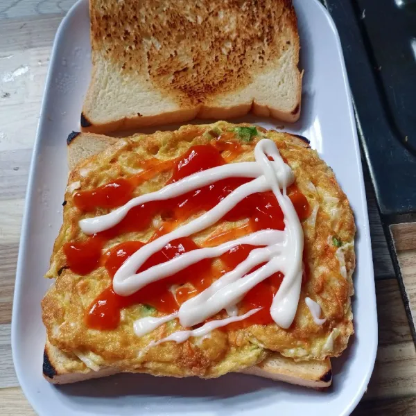 Panggang roti tawar sampai kecoklatan. Letakkan telur diatas roti. Beri saos dan mayonaise. Tutup dengan roti tawar.