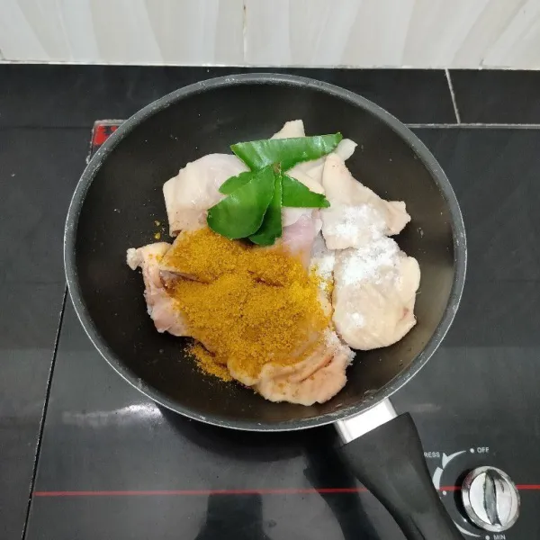 Lalu masukkan ayam ke dalam panci. Tambahkan bumbu ayam goreng instan, daun jeruk dan garam.