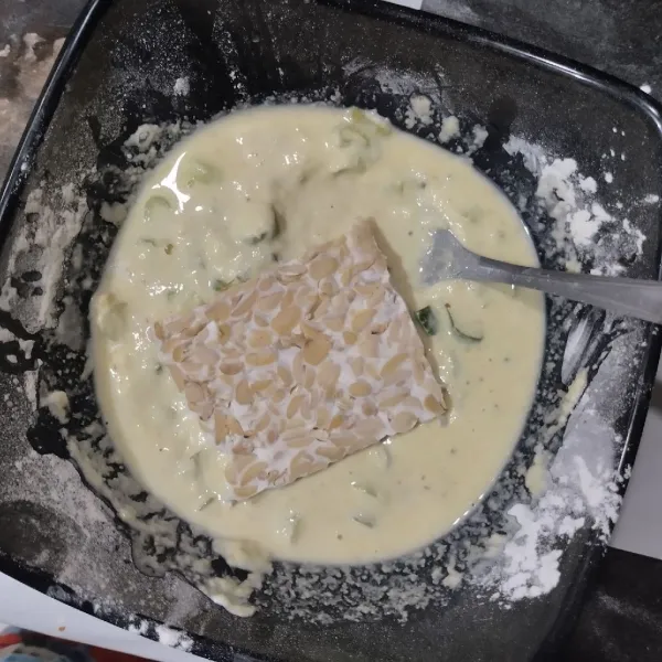 Celupkan tempe ke dalam adonan tepung.