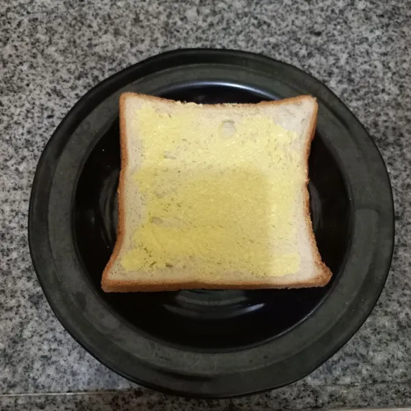 Olesi roti tawar dengan margarin, ratakan.