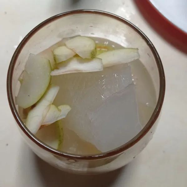 Untuk penyajian, masukkan es batu, apel dan air apel ke dalam gelas.