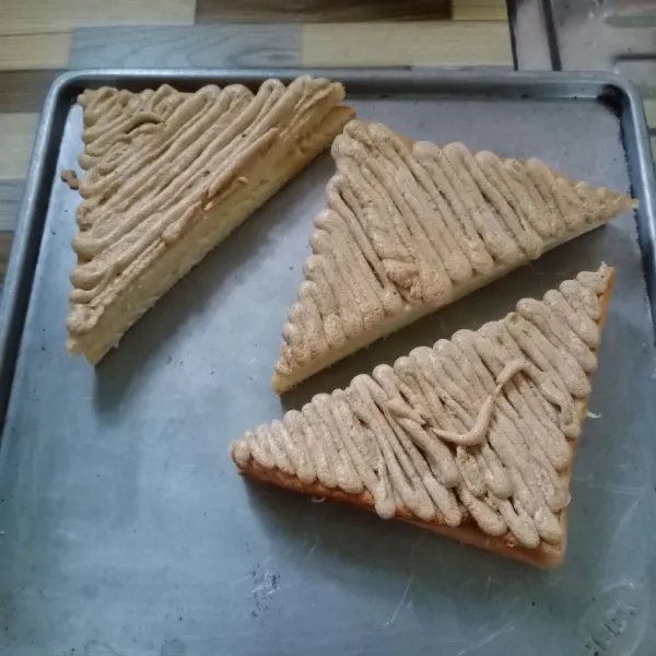 Tutup bagian atas roti dengan 3 potong roti yang lain. Kemudian semprotkan toping diatasnya.