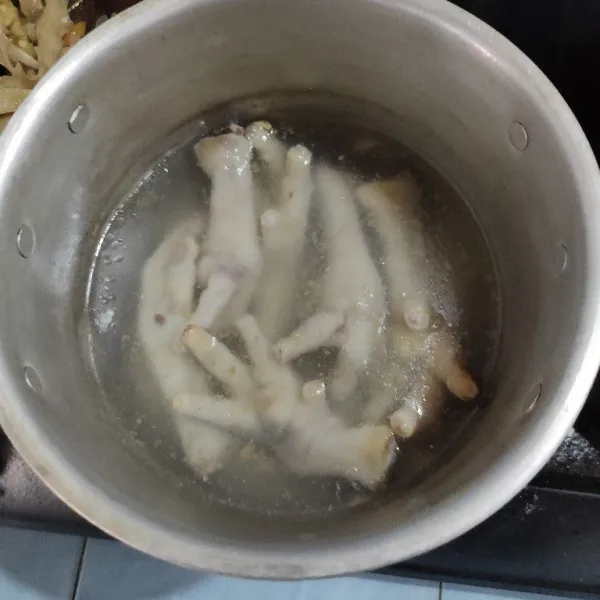 Rebus ceker ayam yang sudah dibersihkan hingga empuk.