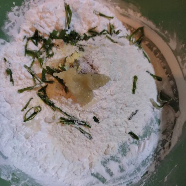 Dalam  tepung tapioka, tepung terigu, daun bawang, garam, kaldu bubuk, serta bawang putih halus, aduk rata.