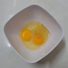 Pecahkan telur, bumbui kaldu bubuk dan garam. Kocok sampai rata.