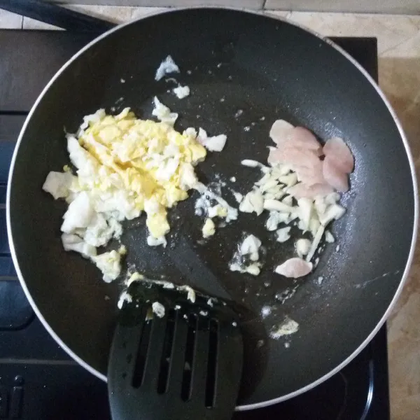 Sisihkan telur, masukkan bawang merah dan bawang putih. Tumis hingga harum, tambahkan daging ayam. Aduk rata.