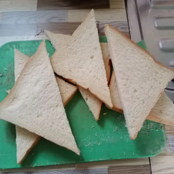 Potong roti tawar menjadi bentuk segitiga.