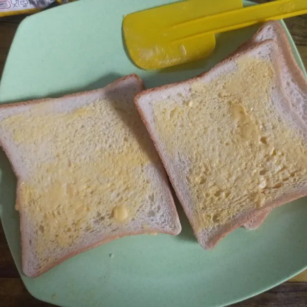 Olesi setiap lembar roti tawar dengan margarin.