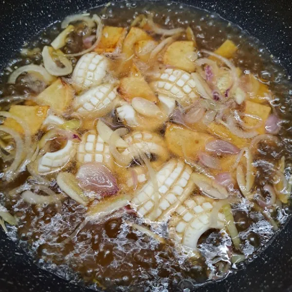 Masukkan kentang goreng dan squid flower. Masak sampai squid flower mengembang.