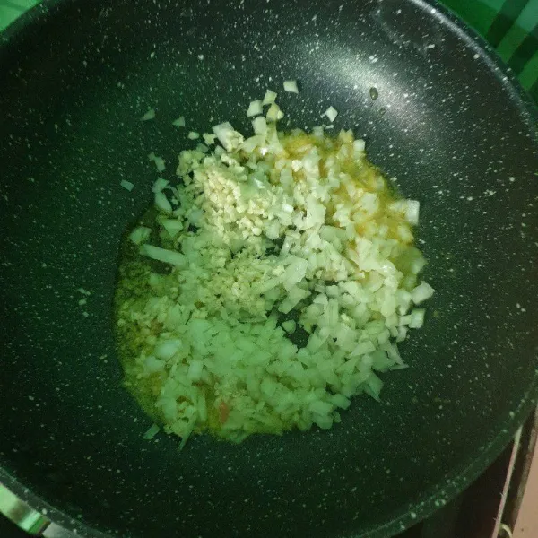 Lelehkan margarin lalu masukkan bawang putih cincang dan bawang bombay masak sampai harum dan layu transparan.