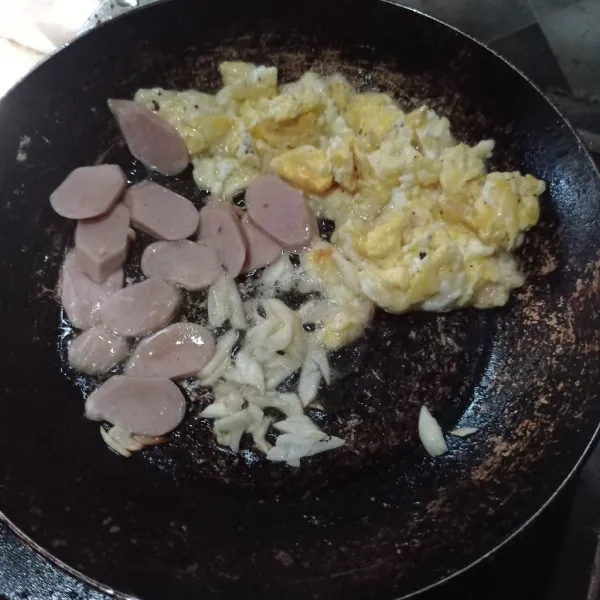 Pinggirkan telur, masukkan bawang putih dan sosis kemudian masak sampai matang, lalu campur.