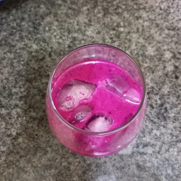 Masukan buah naga yang telah dihaluskan ke dalam gelas yang berisi es batu.