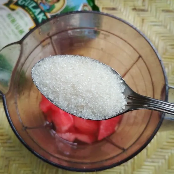 Masukkan potongan buah semangka ke dalam blender kemudian tambahkan gula pasir.