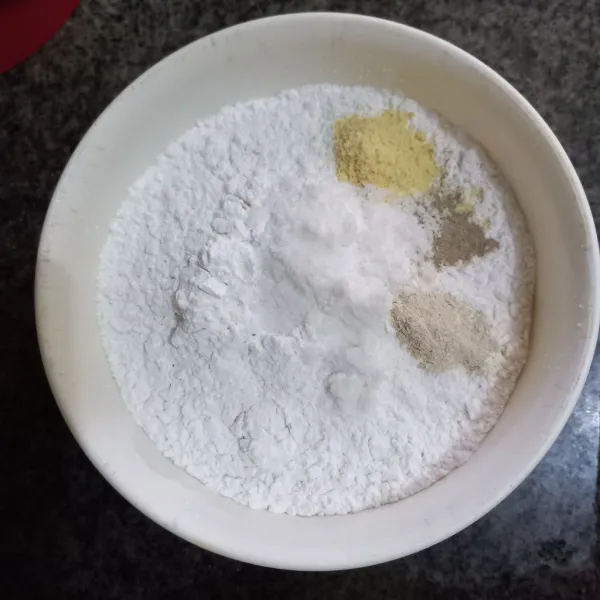 Dalam wadah campur tepung terigu, tepung tapioka, garam, kaldu jamur, merica bubuk dan bawang putih bubuk, aduk rata.