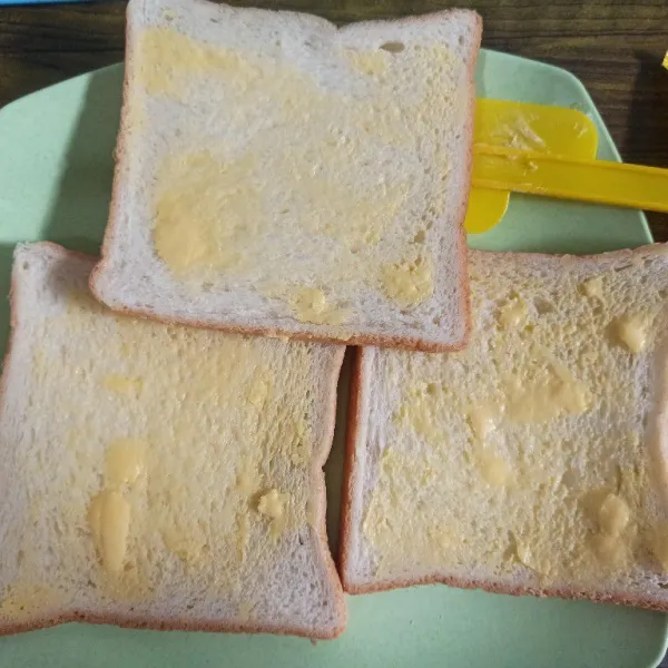 Olesi setiap lembar roti dengan margarin.