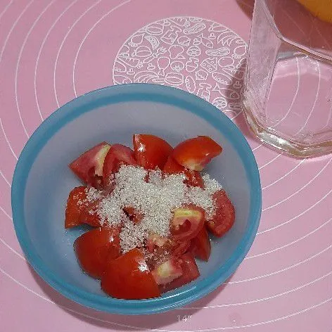 Potong tomat lalu tambahkan gula pasir, aduk rata.