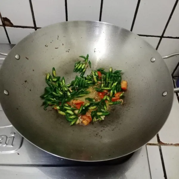 Masukkan cabe iris, taburi garam, gula dan penyedap, aduk rata. Masak sampai cabe layu dan bau langu cabe hilang. Koreksi rasa dan matikan api.