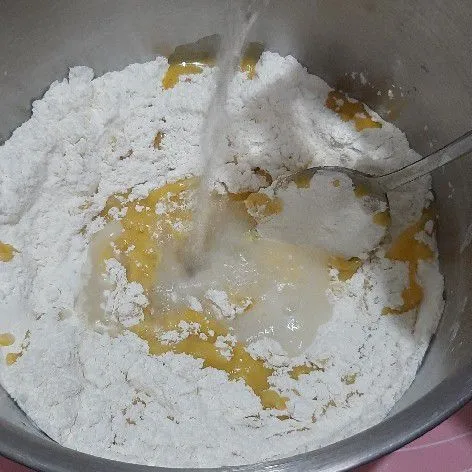 kemudian tuang margarin leleh dan juga air, uleni asal rata.