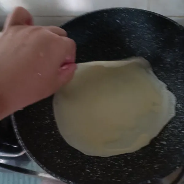 Masak 1 sendok sayur adonan di teflon sampai bagian pinggir terkelupas. Angkat dan tumpuk. Lakukan sampai adonan habis.