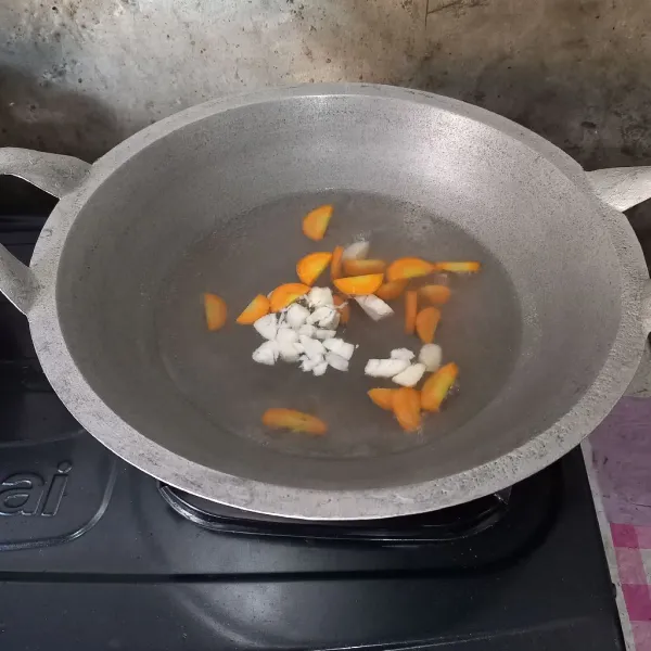 Didihkan air dan bawang putih. Masukkan wortel dan masak sampai setengah empuk.