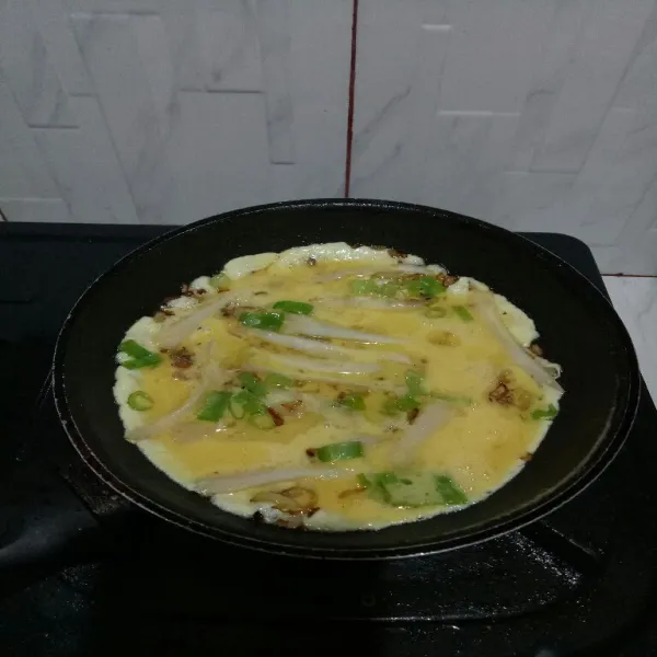 Masukkan telur dan ratakan goreng dengan api sedang sampai sisi bawah berkulit.