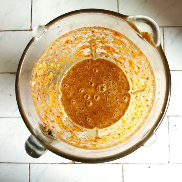 Masukkan kacang goreng, kencur, bawang merah, cabai merah, kemiri, gula jawa dan garam ke dalam blender lalu haluskan.