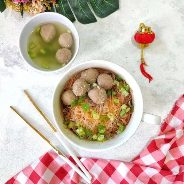 Setelah itu tata bakso diatasnya, taburi dengan daun bawang sajikan dengan kuah baksonya.