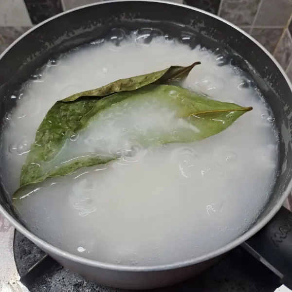 Bubur : Tiriskan beras, bilas dan tiriskan lagi. Masukkan beras dalam panci, beri ½ bagian air dan daun salam. Rebus di atas kompor dengan api sedang sambil diaduk-aduk.