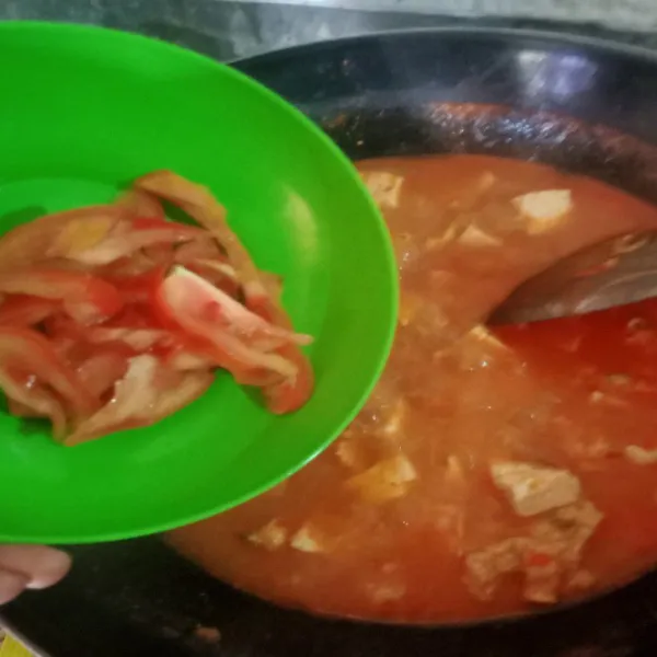 Masukkan irisan tomat, garam dan penyedap, aduk rata.