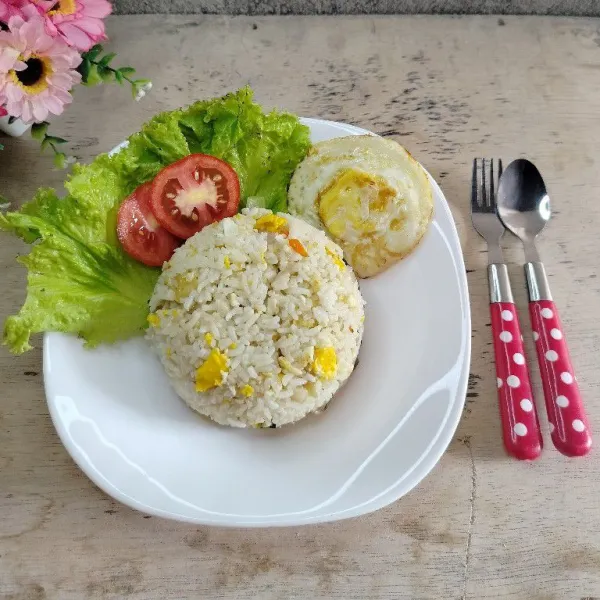 Pindahkan nasi goreng ke piring dan sajikan bersama pelengkapnya.