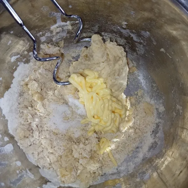 Masukkan butter dan garam, uleni kembali dengan mixer.