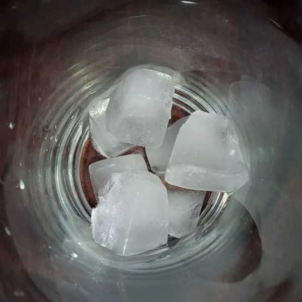 Tuang es batu ke dalam gelas.
