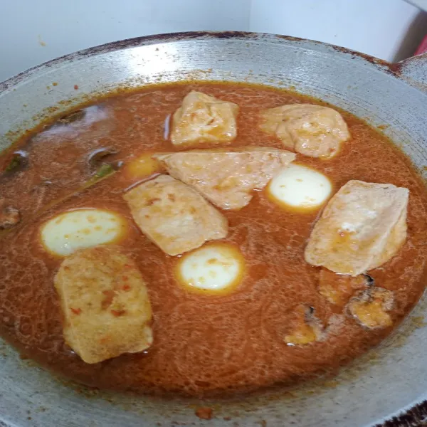 Masukkan telur dan tahu lalu masak hingga kuah meresap dan agak kental. Setelah siap, angkat dan hidangkan.