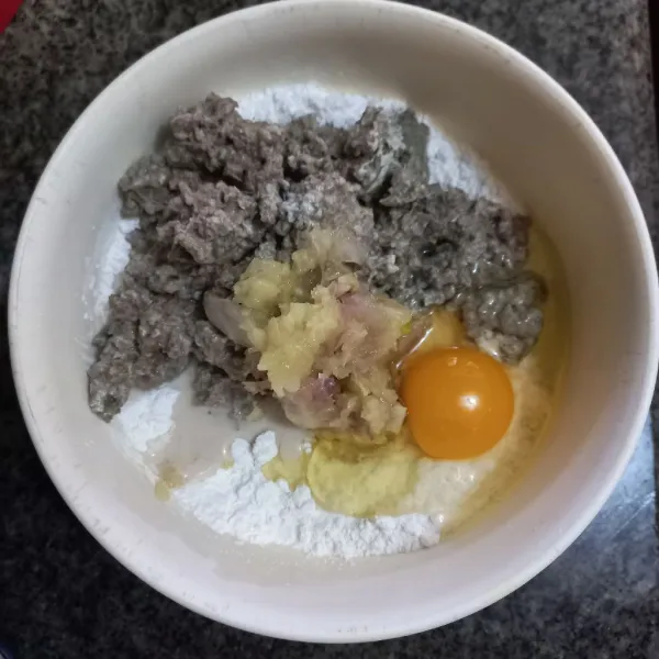 Masukkan telur, bawang putih dan bawang merah yang telah dihaluskan serta kulit ikan tenggiri pada adonan tepung sagu, uleni hingga bisa dibentuk.