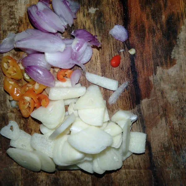 Iris-iris bawang putih, bawang merah, dan cabe rawit.