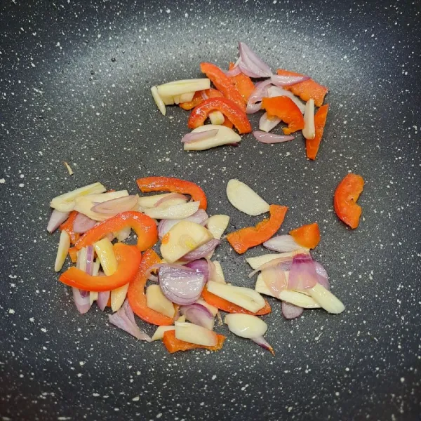 Tumis bawang merah, bawang putih dan paprika sampai layu dan harum.