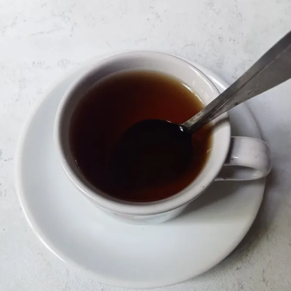 Aduk - aduk sampai gula larut dan keluarkan teh dari cangkir.