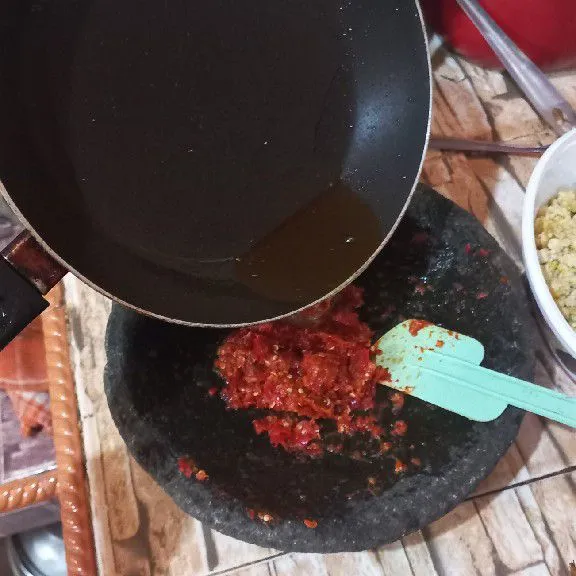 Siram minyak panas ke sambal, aduk rata.