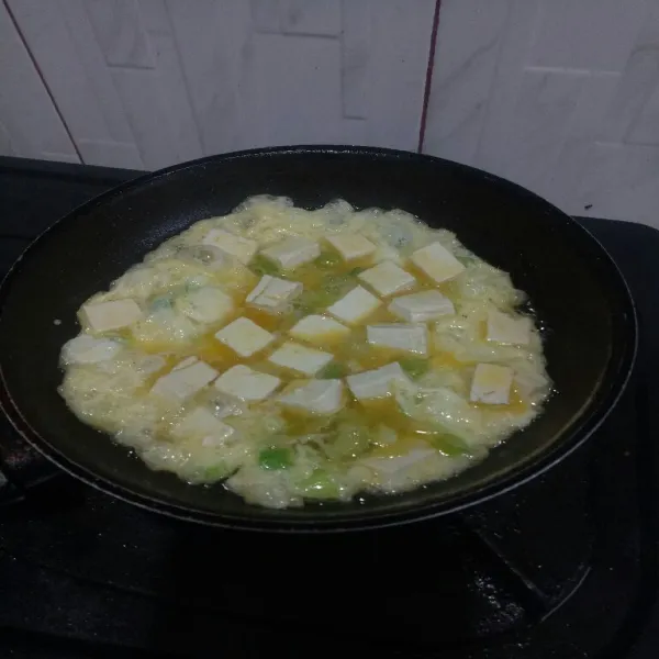 Panaskan minyak diteflon lalu tuang adonan telur masak hingga bagian bawahnya matang.