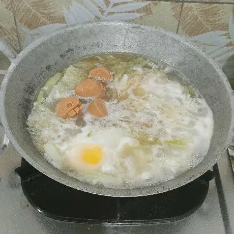 Masukkan bihun, masak sampai bihun berubah warna. Ceplok telur, masukkan sosis, biarkan sampai telur mengeras. Lalu aduk sampai semua tercampur.