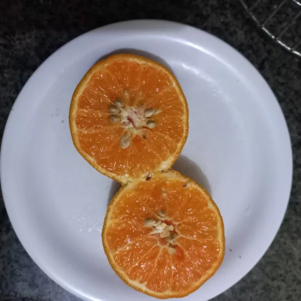 Belah buah jeruk, peras airnya.