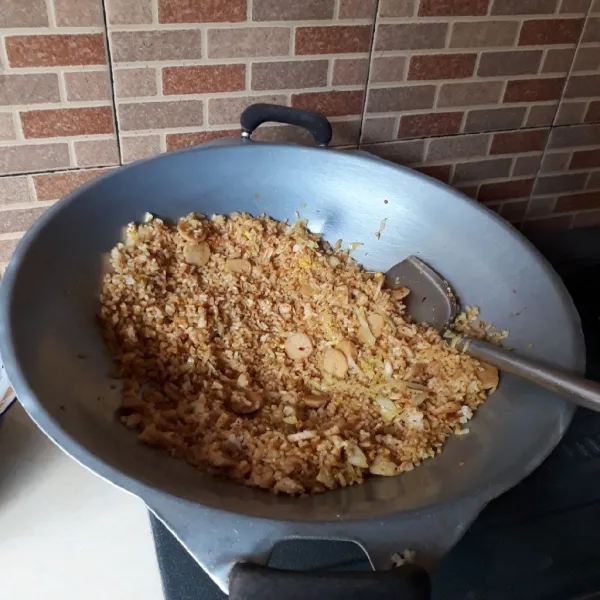 Masukkan nasi, aduk rata. Masak hingga matang dan harum.